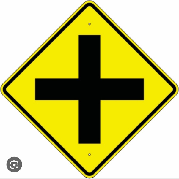 Does the plus sign traffic sign mean crossroad ahead or way intersection ahead because ive gotten multiple answers from tests and booklets saying it means one or the other